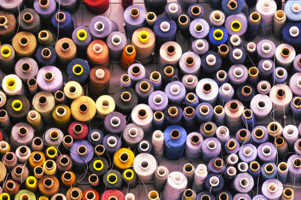 Close-up of fine sewing thread wound on spools