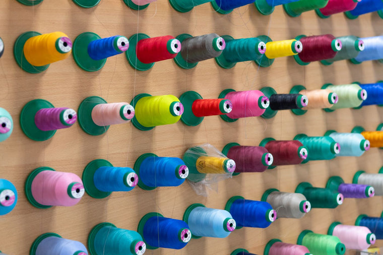 Colourful sewing thread spools arranged together, ready to choose a 10-spool box