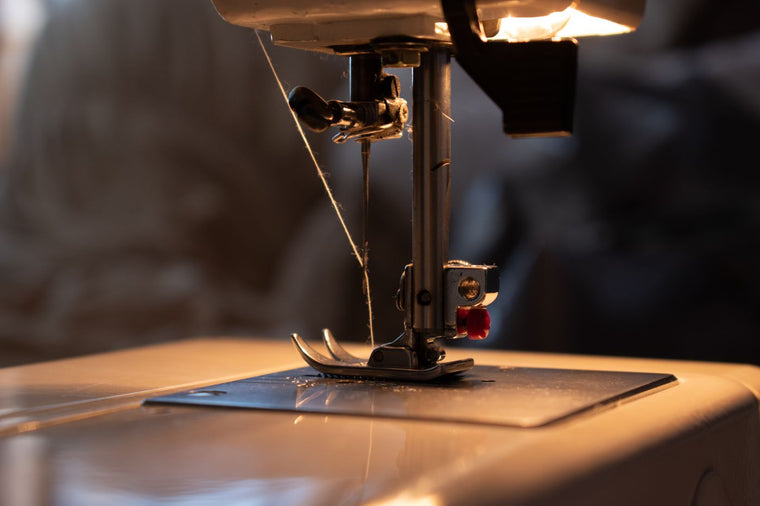 Thread running through the needle area of a sewing machine above the metal needle plate